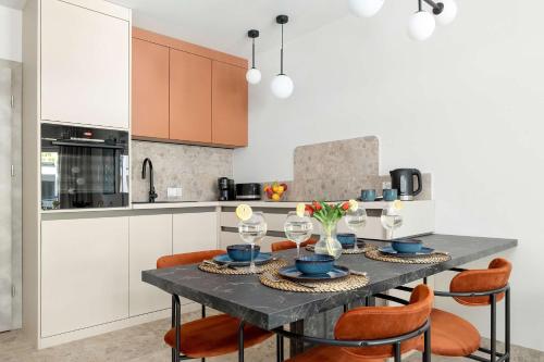 a kitchen with a dining table with orange chairs at Unique Studio with Parking Space and Swimming Pool by Noclegi Renters in Pobierowo