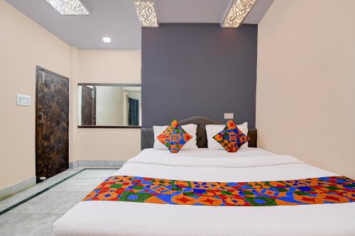 a bedroom with a large bed with a colorful blanket at FabHotel Rajdanga Retreat in Kolkata