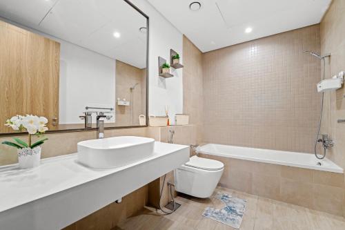 a bathroom with a sink and a toilet and a tub at Contemporary 1BR City View Apartment at 1 Residence in Dubai