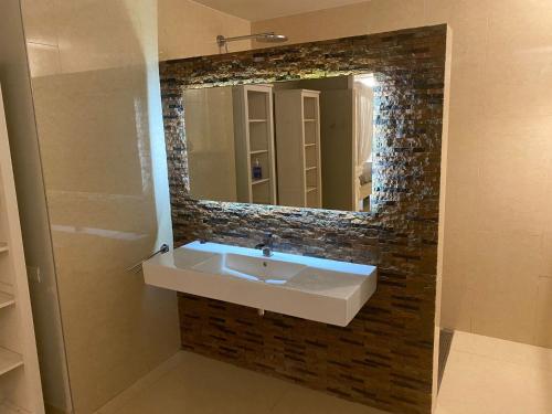 ein Badezimmer mit Waschbecken und Spiegel in der Unterkunft Villa del Mare - Waterfront Villa in Jan Thiel