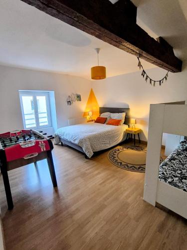 a bedroom with a bed and a table in it at La Mésange - Cosy - 10mn du Parc in Mauléon