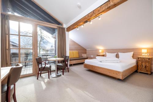 una habitación de hotel con una cama y un balcón en Landhaus Schösser-Brandler, en Mayrhofen