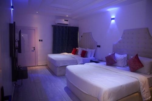um quarto de hotel com duas camas e uma janela em Luxurious Duplex in Oredo, Benin City - Perfect for Families and Groups em Ekae