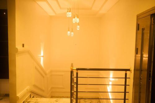um corredor com uma cadeira e um lustre em Luxurious Duplex in Oredo, Benin City - Perfect for Families and Groups em Ekae