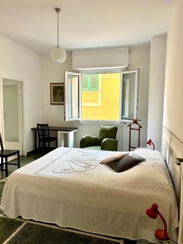 Un dormitorio con una cama y una mesa y una ventana. en Il Mughetto, en Rapallo