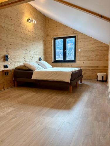 een slaapkamer met een bed in een houten wand bij Chalet Iris, spa privatif, 4p in Rochesson