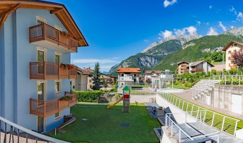 ein Gebäude mit einem Spielplatz mit Rutsche in der Unterkunft Appartamento Alpen Molveno in Molveno