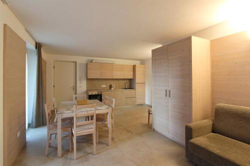 a kitchen and dining room with a table and a couch at Appartamento Alpen Molveno in Molveno
