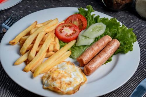 ein weißer Teller mit Pommes frites und Hotdogs in der Unterkunft Villa Mahayoni in Bedahulu