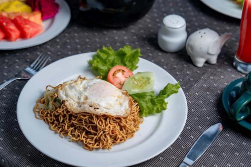ein Teller mit Essen und Nudeln auf einem Tisch in der Unterkunft Villa Mahayoni in Bedahulu
