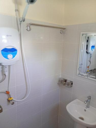 a bathroom with a shower and a sink at Lakeside Beach Hotel in Madwa
