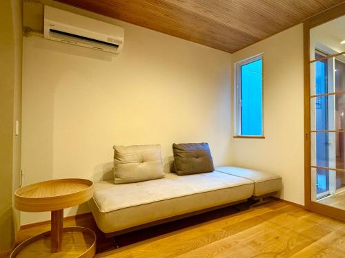 a room with a couch and a table and a window at Villa Monica Premium in Nagoya