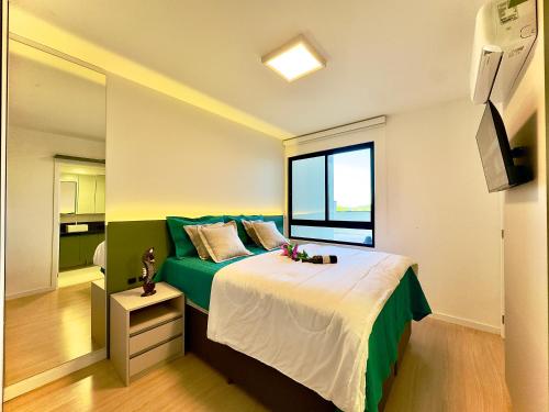 a bedroom with a large bed and a window at Apto Penha a 300M PRAIA 8 min do BETO CARREIRO com PISICNA, sacada com CHURRASQUEIRA privativa, AR CONDICIONADO Wi Fi, PORTARIA 24h,vaga privativa de GARAGEM in Penha