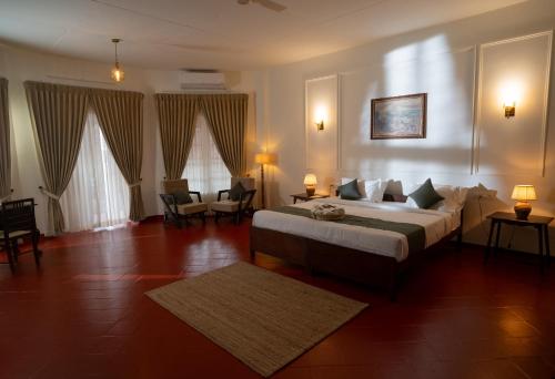 um quarto com uma cama grande em um quarto em The Hundred House by Kisah Stays - Wayanad Colonial Estate Bungalow em Ambalavayal