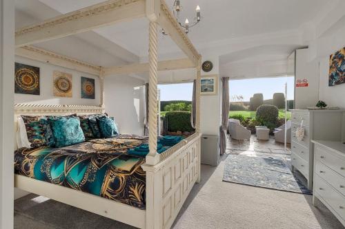 a bedroom with a canopy bed with blue pillows at Manor House Apartment - Indoor Heated Pool, Parking in Torquay