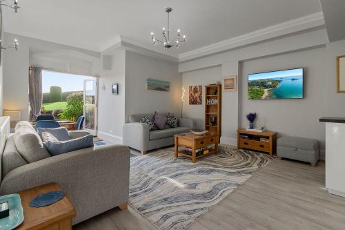 a living room with a couch and a table at Manor House Apartment - Indoor Heated Pool, Parking in Torquay
