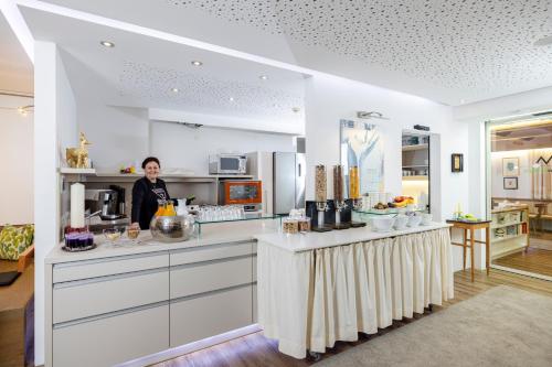 Una mujer parada detrás de un mostrador en una cocina. en Landhaus Schösser-Brandler, en Mayrhofen