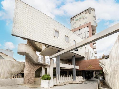 a building with a curved roof and a tall building at APA Hotel Kanazawa Nomachi in Kanazawa