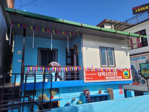 a man sitting on a balcony of a building at DHARAMSHALA inn MUNSYARI in Munsyari