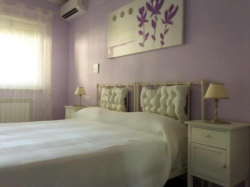 een slaapkamer met een groot wit bed en een raam bij B&B EurGardenie in Rome