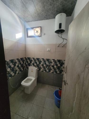 a small bathroom with a toilet and a window at DHARAMSHALA inn MUNSYARI in Munsyari