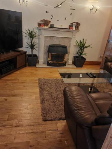a living room with a couch and a fireplace at Festohomes1 at rushden in Rushden