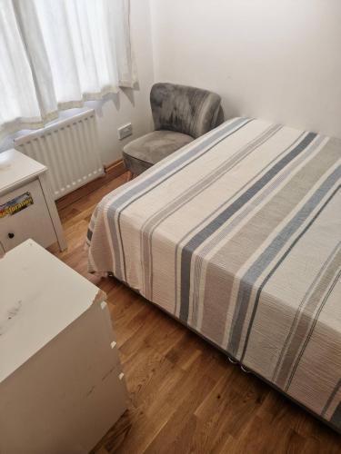Una cama y una silla en una habitación con una caja. en Festohomes1 at rushden, en Rushden