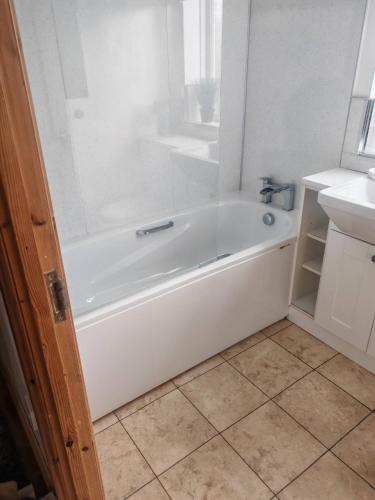 y baño con bañera blanca y lavamanos. en Festohomes1 at rushden, en Rushden