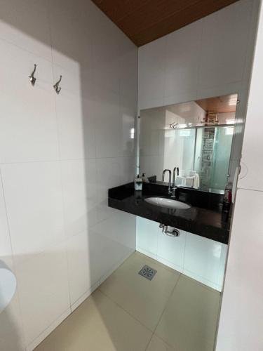 un baño con lavabo y espejo en Quarto privado próximo ao centro 13, en Manaus