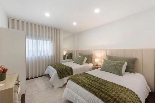 a bedroom with two beds and a window at Casa São Domingos in Travanca