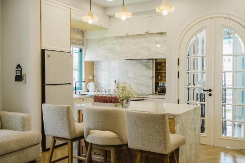 eine Küche mit einer großen Insel mit Stühlen drum herum in der Unterkunft Le Chattok Villa in Bình Tú