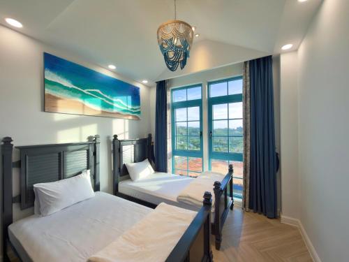 1 Schlafzimmer mit 3 Betten und einem Fenster in der Unterkunft Le Chattok Villa in Bình Tú