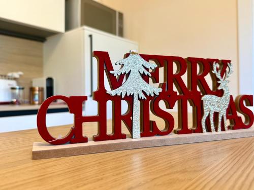 a red sign that reads merry christmas in a kitchen at Green garden apartment in Lignano Sabbiadoro