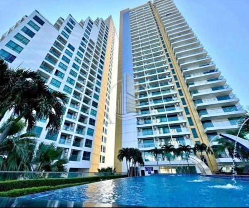two large buildings with palm trees and a swimming pool at Sea View Studio in Pattaya South