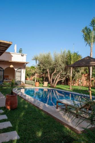 a swimming pool with a bench next to a house at Najma Ourika in Ourika