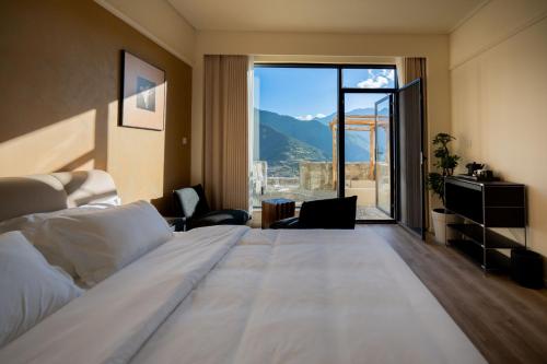 a hotel room with a large bed and a large window at Endless Summer Cloudscape Hot Springs Siguniang Mountain in Mount Siguniang