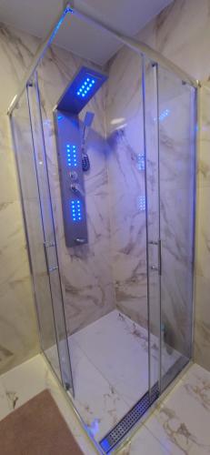 een glazen douche met blauwe verlichting in een kamer bij Apartments Dubrava 6 in Zagreb