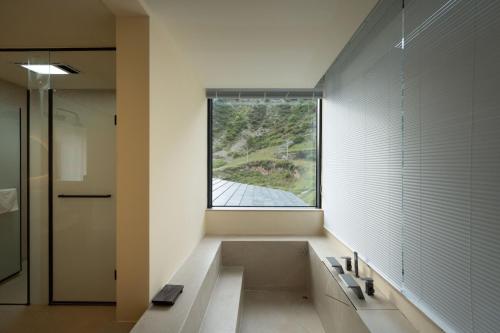 a bathroom with a large window and a bath tub at Endless Summer Cloudscape Hot Springs Siguniang Mountain in Mount Siguniang