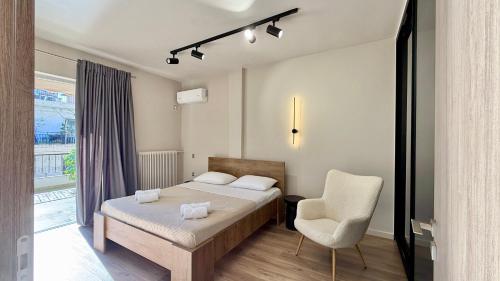 ein Schlafzimmer mit einem Bett, einem Stuhl und einem Fenster in der Unterkunft SKY 5 Luxury Apartment in Kalamata
