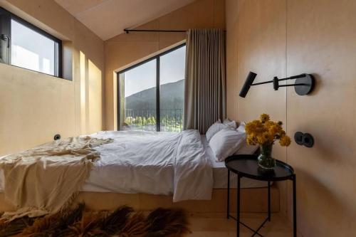 a bedroom with a bed with a window and a table at Barnhouse Tatariv in Dobrovelychkivka