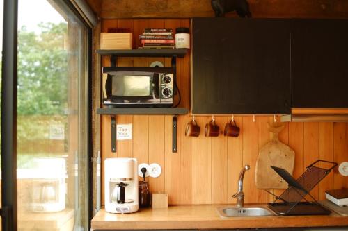 a kitchen with a sink and a microwave on a counter at Villa Várzea - Barn Nest in Várzea