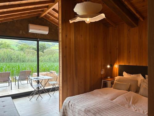 a bedroom with a bed and a patio with a table at Villa Várzea - Barn Nest in Várzea