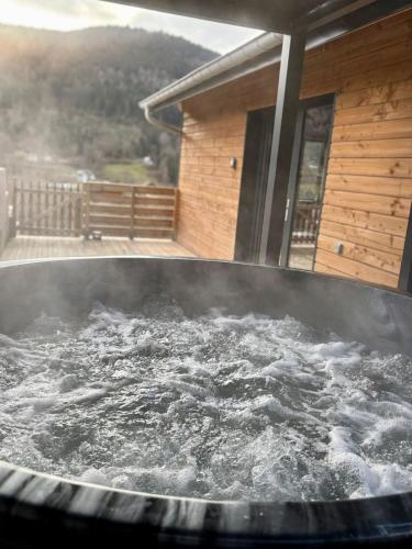 ein großer, mit Wasser gefüllter Whirlpool vor einem Haus in der Unterkunft Chalet Muguet, spa privatif, 4p in Rochesson