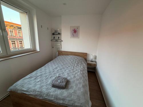 ein kleines Schlafzimmer mit einem Bett und einem Fenster in der Unterkunft ApartmentsByMatyrafa-XIV in Tarnowitz