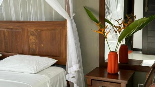 a bedroom with a bed and two vases with plants at Priima in Ahangama