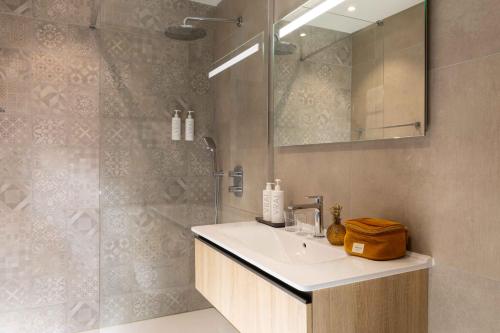 un baño con lavabo y ducha en Hôtel Le Pré Galoffre, en Nimes