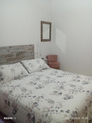Un dormitorio con una cama con un edredón floral. en CASA el NOGAL, en Salas Bajas