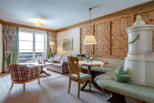 莱尔莫斯Hotel Post Lermoos superior的客厅里有一张沙发、一张桌子和几把椅子。