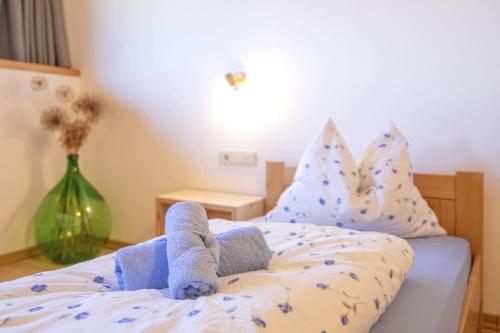 a pair of stuffed animals sitting on a bed at Rieplhof - Relaxing farm stay with breakfast and mountain view in Vipiteno