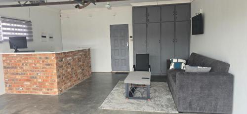 een woonkamer met een bank en een tafel bij Good night guest house in Polokwane